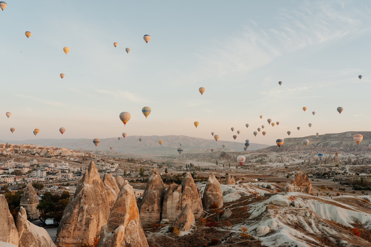 Dozens of colourful hot air balloons floating above the fairy chimneys of Cappadocia at sunrise