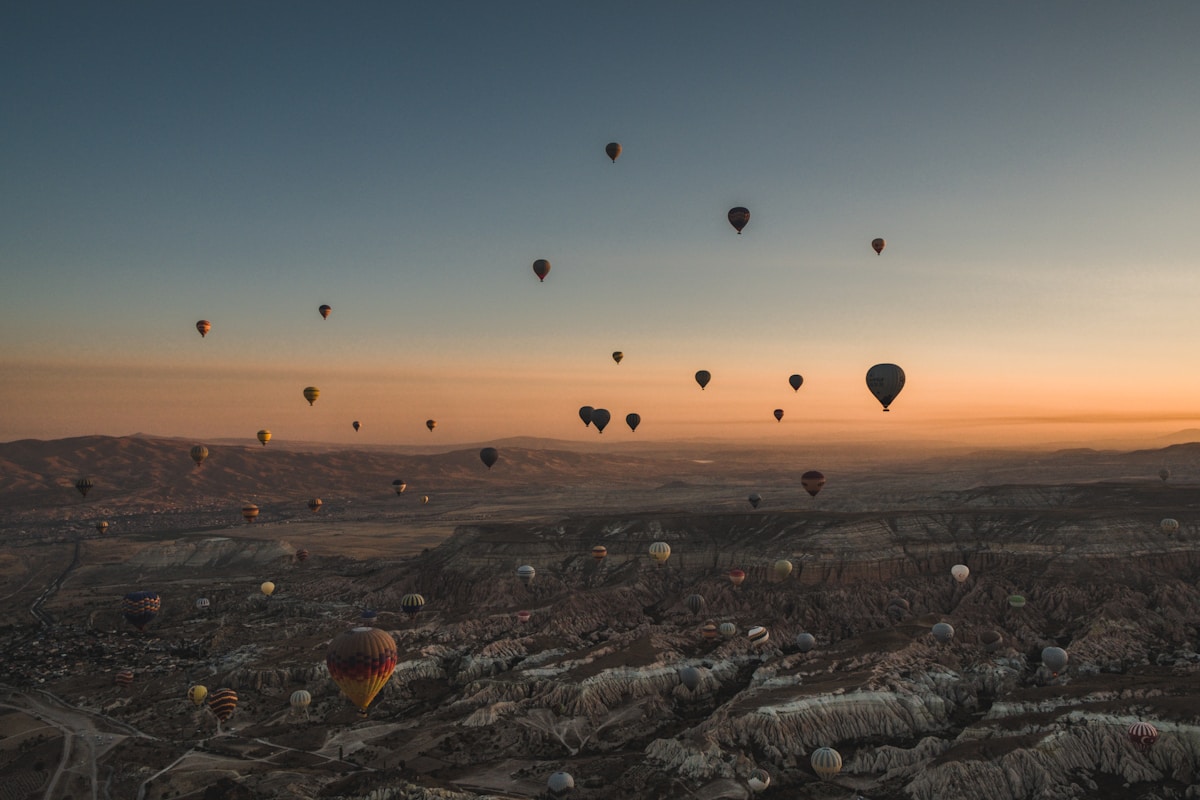 Hot air balloons over Cappadocia's valleys at sunset, Turkey